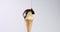 Vanilla ice cream corn revolving on its axis and liquid caramel covering a ball