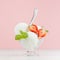 Vanilla ice cream scoops in elegant bowl with silver spoon, strawberry slices, green mint in modern stylish pastel pink interior.