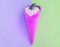 Vanilla pink ice cream cone with chocolate on a background of pastel shades of green and lilac, tinted shot