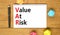 VAR Value at risk symbol. Concept words VAR Value at risk on beautiful white note. Beautiful wooden table wooden background.