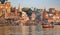 Varanasi historic city with ancient architectural buildings and temples along the Ganges river bank as viewed from a boat.