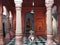 Varanasi, India: Interior of a hindu temple with pillars, Stone diety bull Nandi and bell swinging on top.