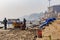 VARANASI, INDIA - JANUARY 29, 2020: Indian casual morning life on Ganga river in Varanasi. A boat under repairs.