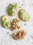 Variation avocado sandwich - with crispy bacon, quail egg, tomatoes, goat cheese, green peas, radish, cucumber. Healthy snack. On