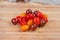 Varicolored cherry tomatoes on the wooden cutting board