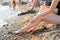 Varicosity. The woman shows the vascular mesh on the lower leg with her hand. Legs close-up. In the background the beach and the