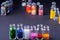 Varied colors beads in transparent bottles row dark background