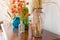 Varied vases with dry plants on an old antique vintage mahogany chest of drawers