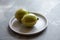 Variegated pink lemons with green-striped rind in grey plate on concrete table