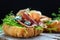 Variety of aperitifs Croissant sandwiches with jamon ham serrano paleta iberica, blue cheese, avocado, microgin on blue background