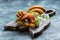 Variety of aperitifs Croissant sandwiches with jamon ham serrano paleta iberica, blue cheese, avocado, microgin on blue background