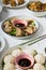 Variety of Asian-style dishes with gyozas, steamed xiaolongbao, and rice three treats on restaurant table. Vertical image