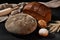 Variety of baked bread and buns with sesame and sunflower seeds, sprinkled with flour. Bunch of wheat, burlap, rolling