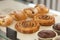 Variety baked muffins and buns in glass showcase at bakery cafe