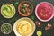 A variety of colored hummus, classic, beetroot and avocado. Top view, dark rustic background. Toned photo.