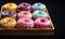 Variety of colorful donuts, freshly baked and adorned with glaze and sprinkles, are showcased in a tempting array