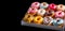 Variety of colorful donuts, freshly baked and adorned with glaze and sprinkles, are showcased in a tempting array