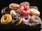 Variety of colorful donuts, freshly baked and adorned with glaze and sprinkles, are showcased in a tempting array