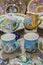 Variety of Colorfully Painted Ceramic Pots in an Outdoor Shopping Market. pottery in the shop window. Clay cups and plates.