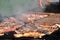 Variety of different kind of meat steaks, meatballs, shish kebab, fillet, burgers and sausages with bread on a grill outdoor.