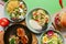 Variety of food dishes on bright green background. Table covere with food flat lay, top view, frame