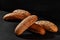 Variety of fresh baked bread with black and white sesame seeds against dark background with copy space. Rural cuisine or