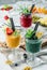 Variety of fresh tropical smoothies with kiwi, mint, blueberries, strawberry, mango in jars glass on light background. Summer cold