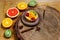 Variety of fruits grapefruit, oranges, kiwi, lemon, mint, cake, sweet fruit dessert on a plate on a wooden board, on the stump the