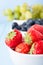 Variety of Fruits in Separate White Ceramic Bowls on Light Blue