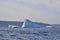 Variety of icebergs along the coast in bay outside St. John\\\'s with steep cliffs on the horizon