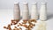 a variety of lactose-free milk from nuts and grains in glass bottles. light vegan concept with a milk drink made from hazelnuts,