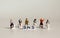 A variety of miniature people sitting with  `SNS` alphabetical white cube.