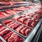 A variety of neatly arranged and labeled cuts of red meat fill a display case in a supermarket.