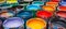 Variety of open paint cans on vibrant multicolored background for artistic projects