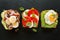 Variety of open sandwich,  wholemeal bread slices  with various toppings: smoked tuna, egg, lettuce, tomatoes, mozzarella, avocad