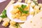 Variety of parmesan and maasdam pieces cheese in the kitchen on light background.