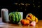 Variety of pumpkins and candles on rustic wooden table and black background with bokeh. Autumn symbolic vegetables in green,