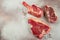 Variety of Raw Black Angus Prime meat steaks T-bone, tomahawk, New York steak. Set raw marbled beef strip loin steaks. place for