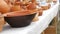 A variety of red clay utensils, ceramic pottery art on the outdoor counter. Street market exhibition of handmade pots