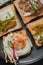 Variety of sandwiches for breakfast, snack, appetizers with fried egg, peanut paste, pea microgreen. Flat lay, top view