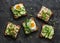 Variety sandwiches with cream cheese, egg, asparagus, avocado, cucumber, shrimp, micro greens on a dark background, top view
