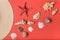 Variety of seashells and part of straw hat. Living coral on the background. Flat lay. Marine concept