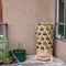 A variety of small starter herbs and vegetables are planted vertically on an apartment patio garden