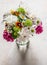 Variety of summer flowers - peonies, hydrangeas, daisies, carnations bouquet on a stone light background, top view. Florist