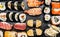 Variety of sushi: maki, nigiri,rolls on dark wooden background