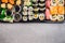 Variety Sushi : rolls, nigiri, maki, out rolls and inside rolls on gray stone background, top view