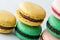 Variety of sweet macaroons are stacks on gray table. Modern european French cuisine.