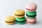 Variety of sweet macaroons are stacks on gray table. Modern european French cuisine.