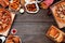 Variety of take out and fast foods, top view frame on a dark wood background