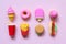 A variety of toy fast food and different sweets in miniature with shadows on a soft pink background